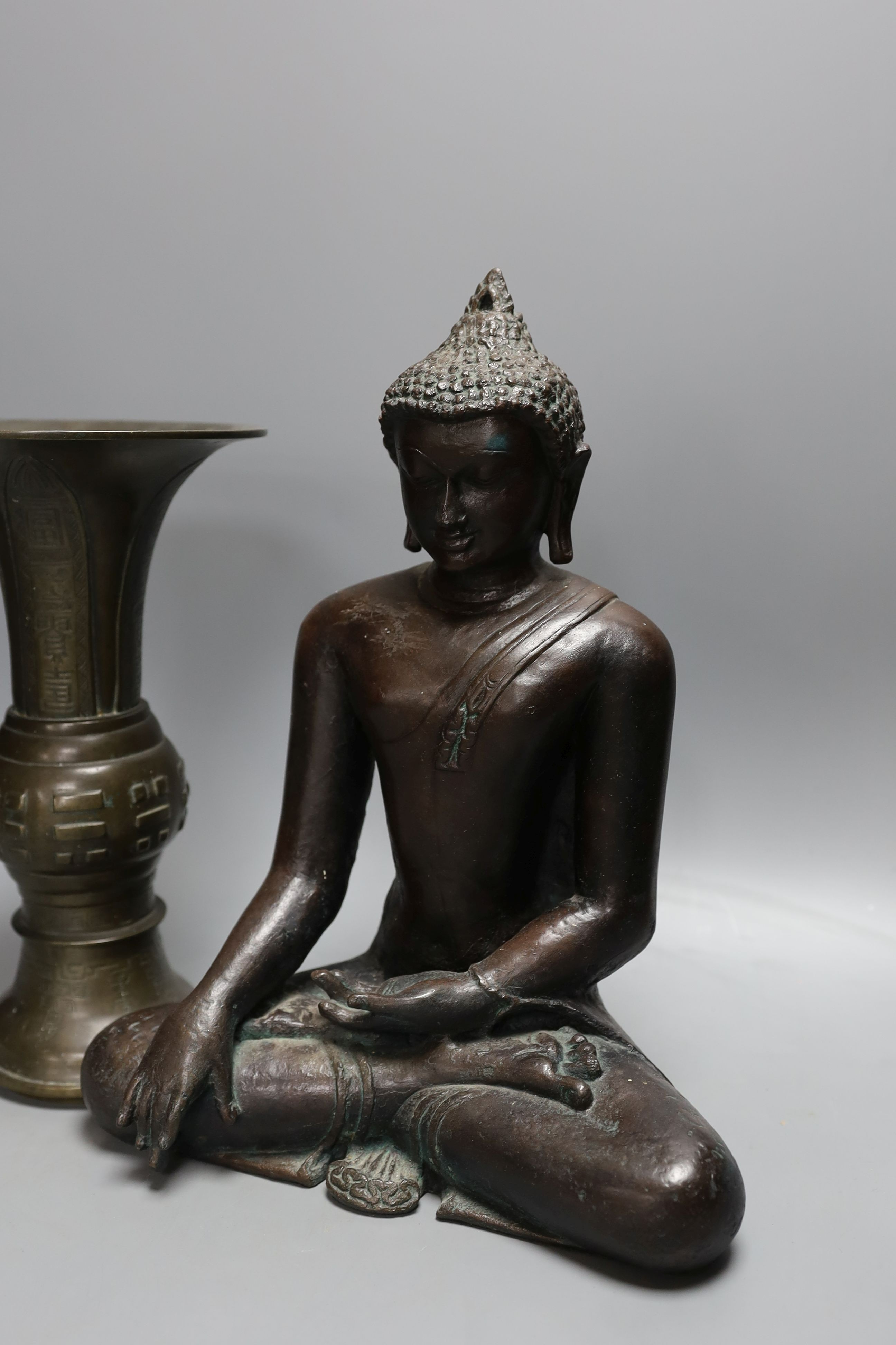 A Chinese bronze vase, 26cm high, inscription to base, together with a bronzed composition seated buddha figure